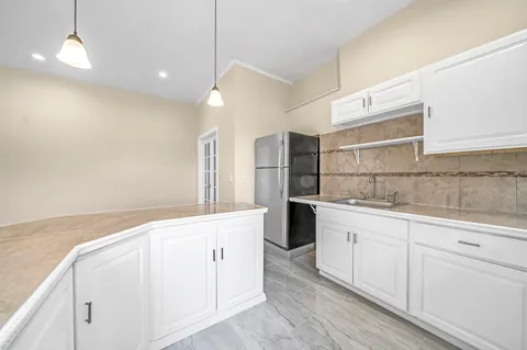 a kitchen with granite countertop white cabinets and white appliances