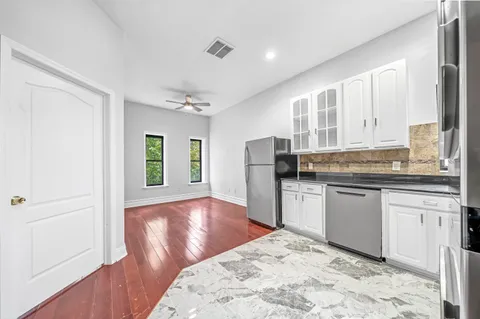 a kitchen with stainless steel appliances granite countertop a refrigerator and a stove top oven