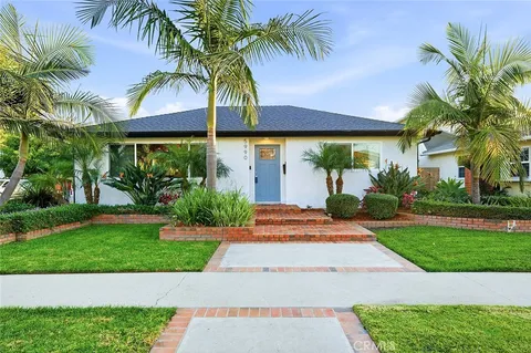 a view of a house with a yard and palm trees