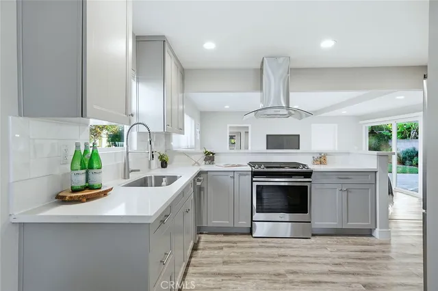 a kitchen with stainless steel appliances granite countertop a sink stove and refrigerator