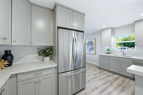 a kitchen with stainless steel appliances granite countertop a refrigerator and a sink