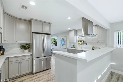 a kitchen with white cabinets and refrigerator