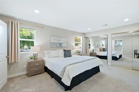 a bedroom with a bed a table and large mirror