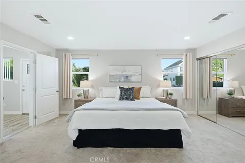 a bedroom with a large bed and a chandelier
