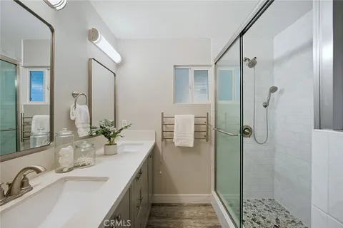 a bathroom with a double sink shower and a mirror
