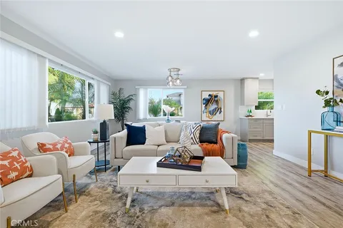 a living room with furniture large window and wooden floor