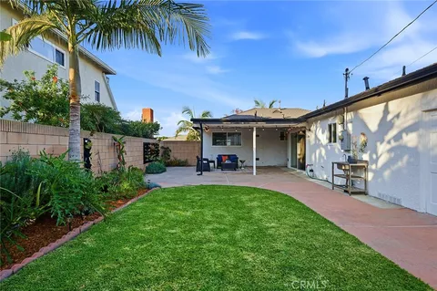 a view of a house with backyard and sitting area