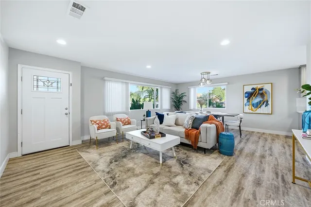 a living room with furniture and a wooden floor