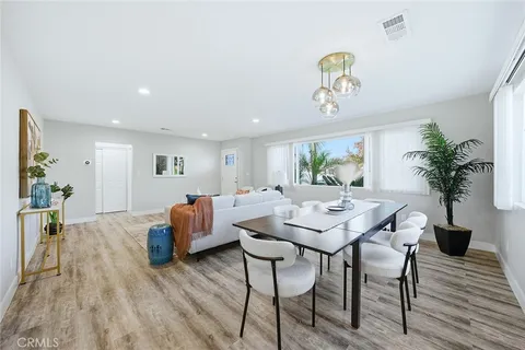 a view of livingroom and dining room with furniture wooden floor