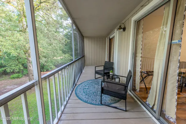 a view of a balcony with furniture and floor to ceiling window