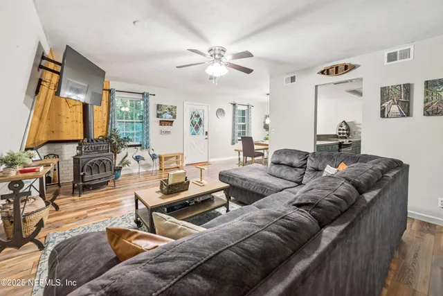 a view of a dining room with furniture a rug and wooden floor