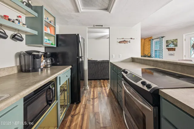 a kitchen with stainless steel appliances a sink and a refrigerator