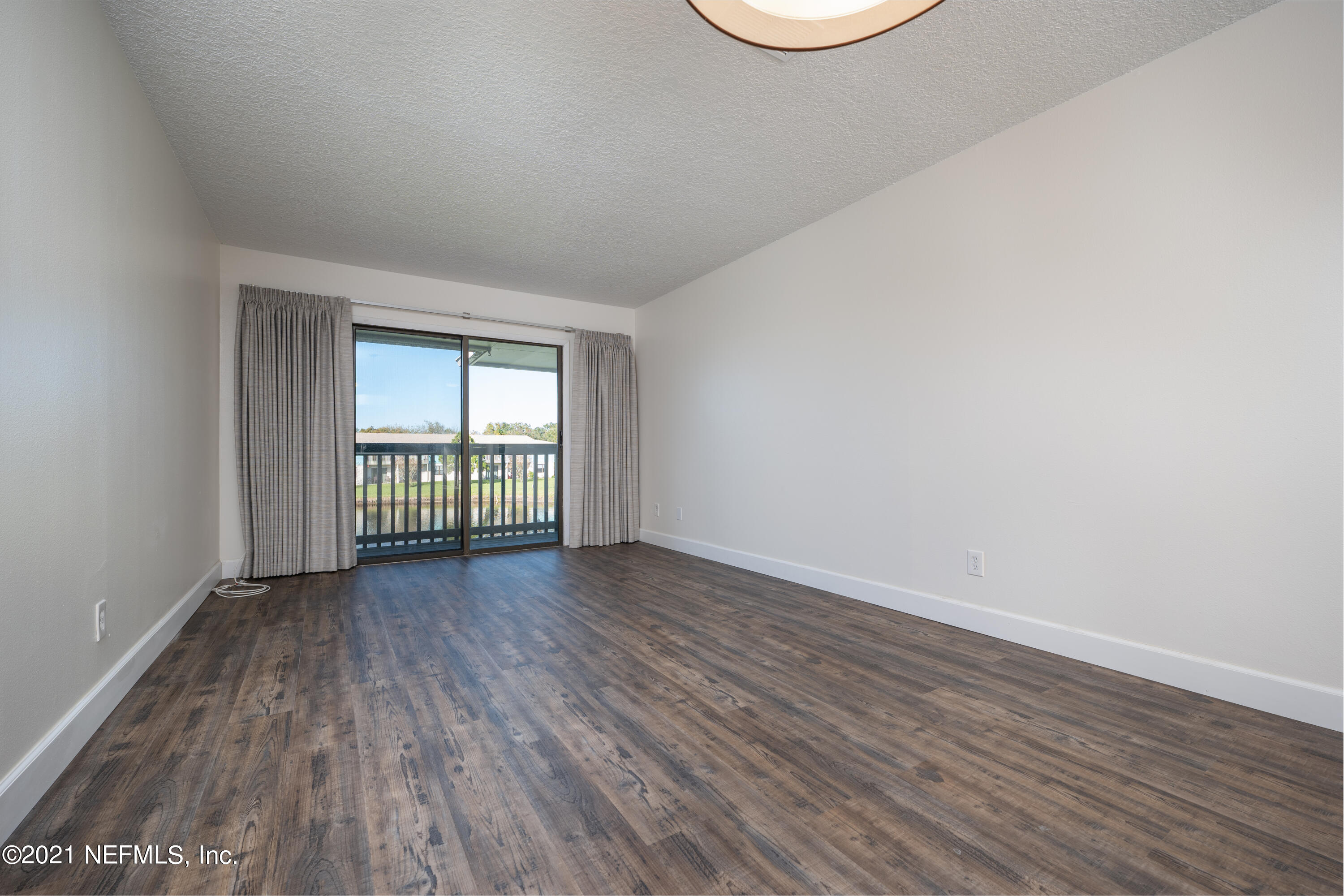 650 Pope Road, Unit 228 St. Augustine, FL 32080 - Photo 8 of 20 an empty room with wooden floor and windows