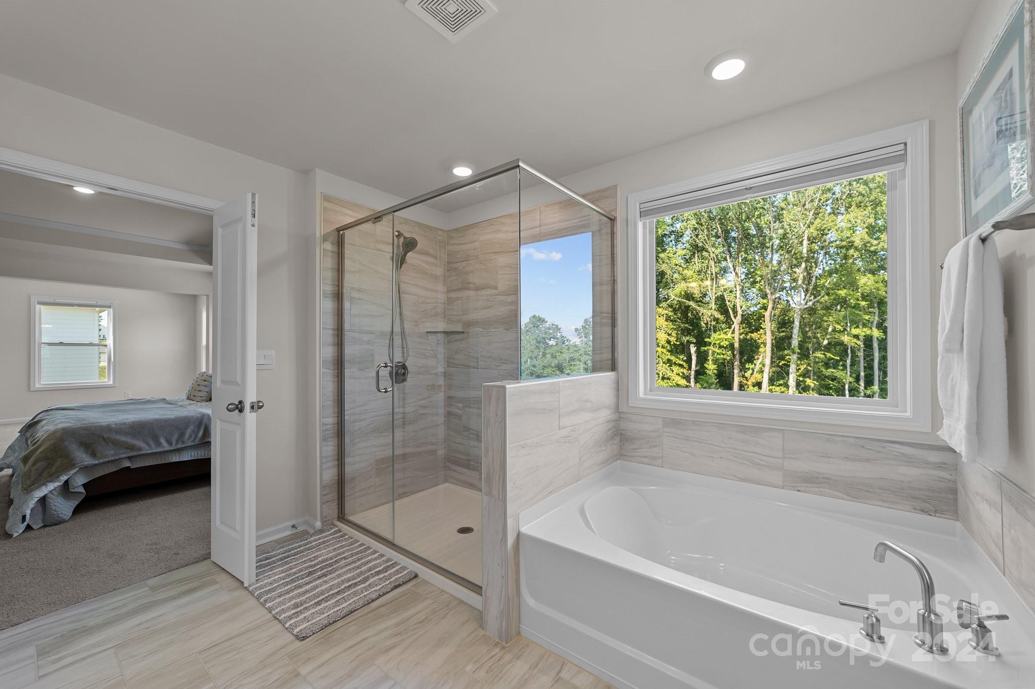 6037 Treehouse Drive Charlotte, NC 28214 - Photo 26 of 48 a bathroom with a tub shower and window
