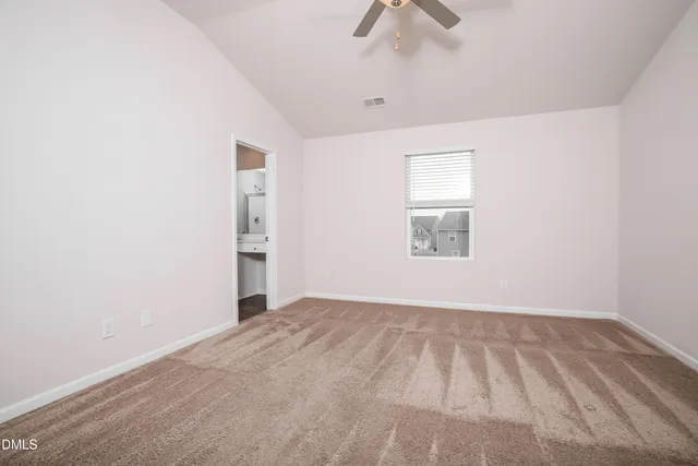 an empty room with a window and a ceiling fan