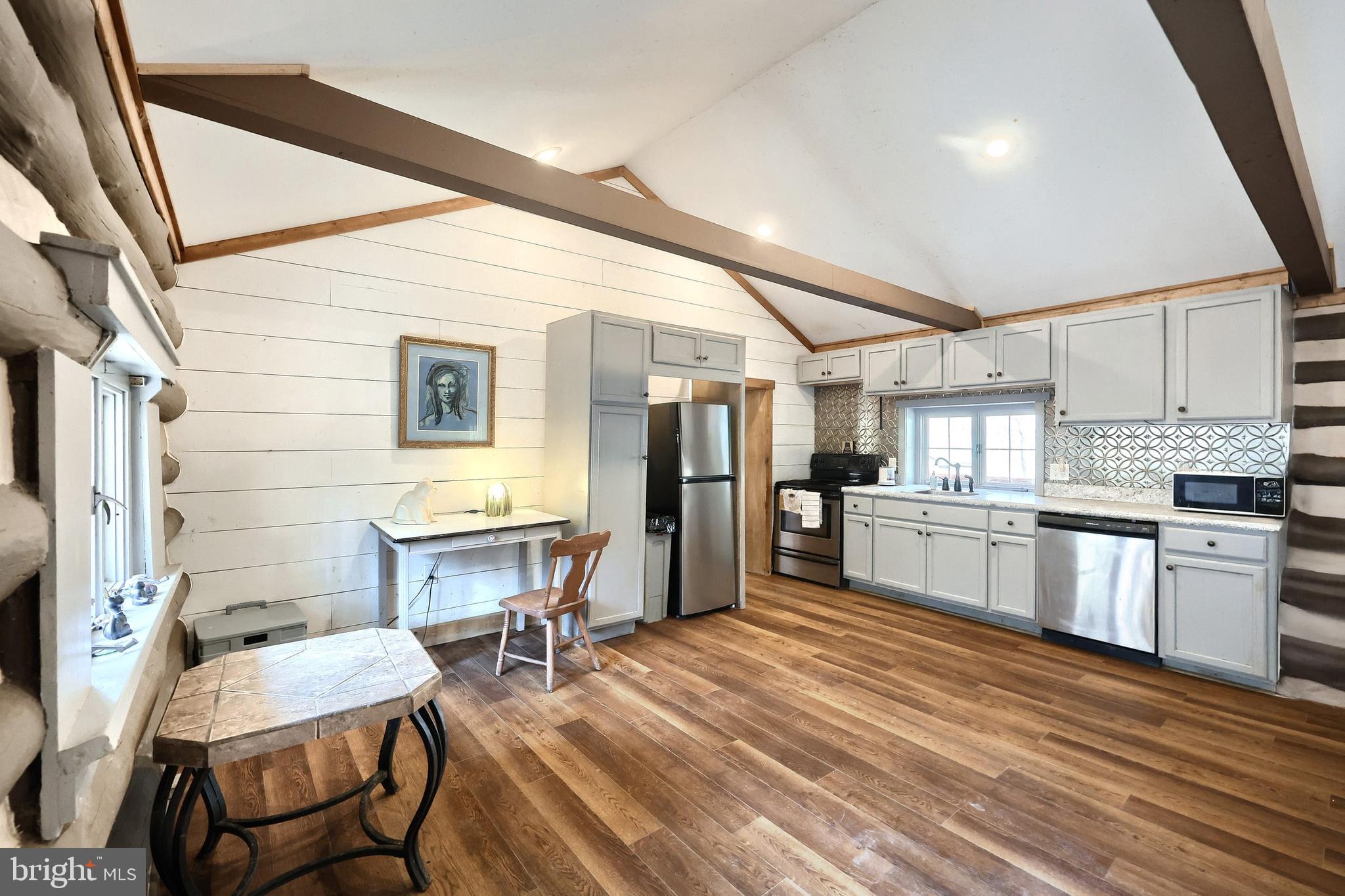 6227 Pigeon Hill Road Spring Grove, PA 17362 - Photo 6 of 50 a kitchen with stainless steel appliances wooden floor dining table chairs and wooden cabinets