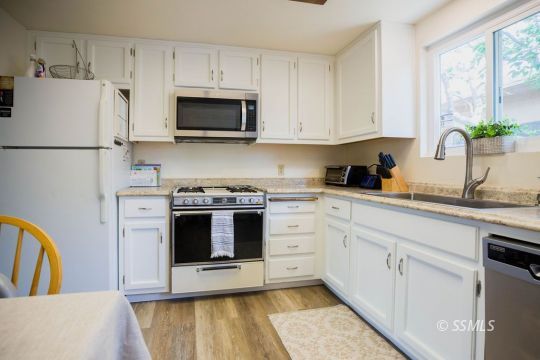 122 South Valley Street Ridgecrest, CA 93555 - Photo 10 of 26 a kitchen with white cabinets and white appliances