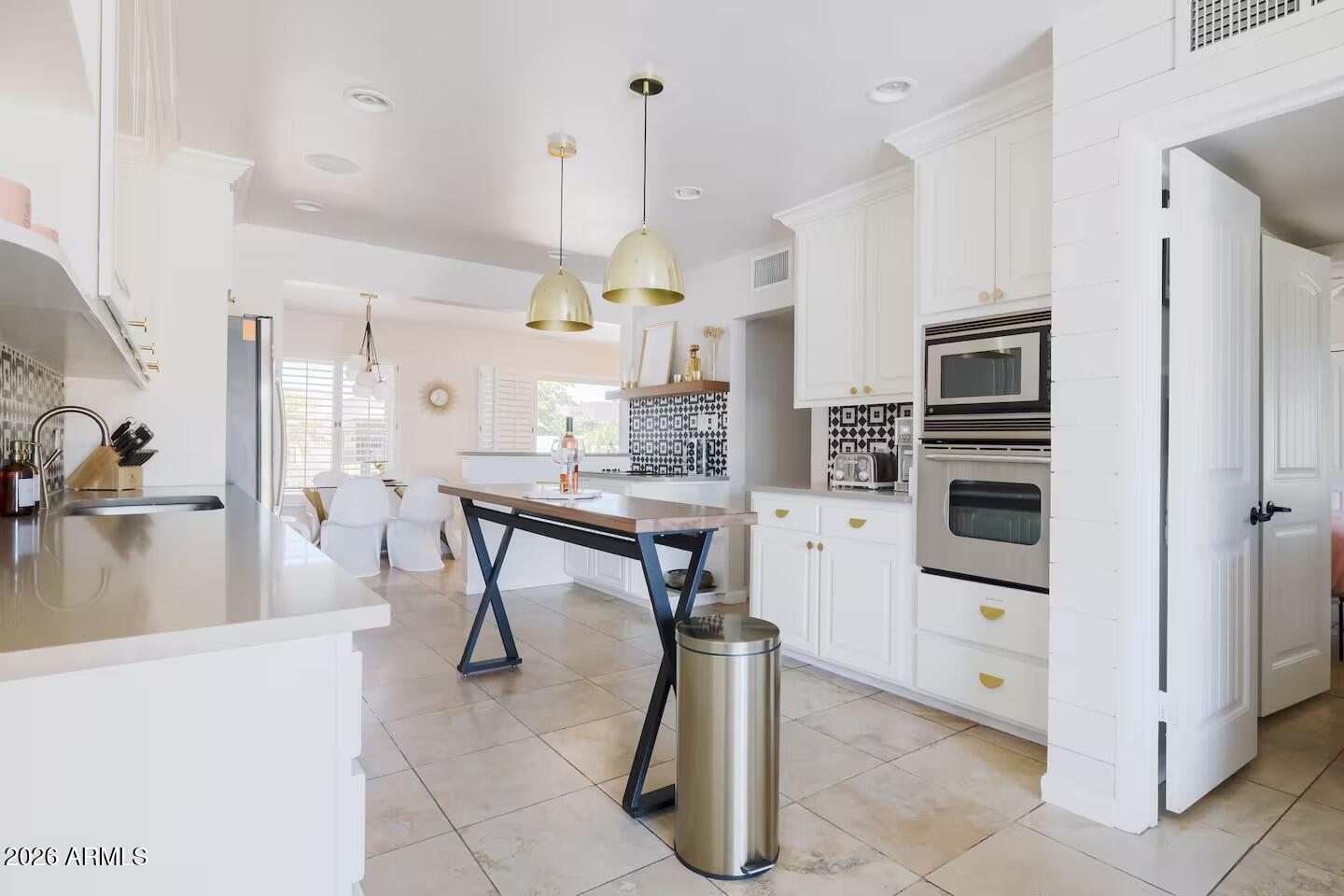 6810 East Granada Road Scottsdale, AZ 85257 - Photo 12 of 34 a kitchen with stainless steel appliances kitchen island granite countertop a table and chairs in it