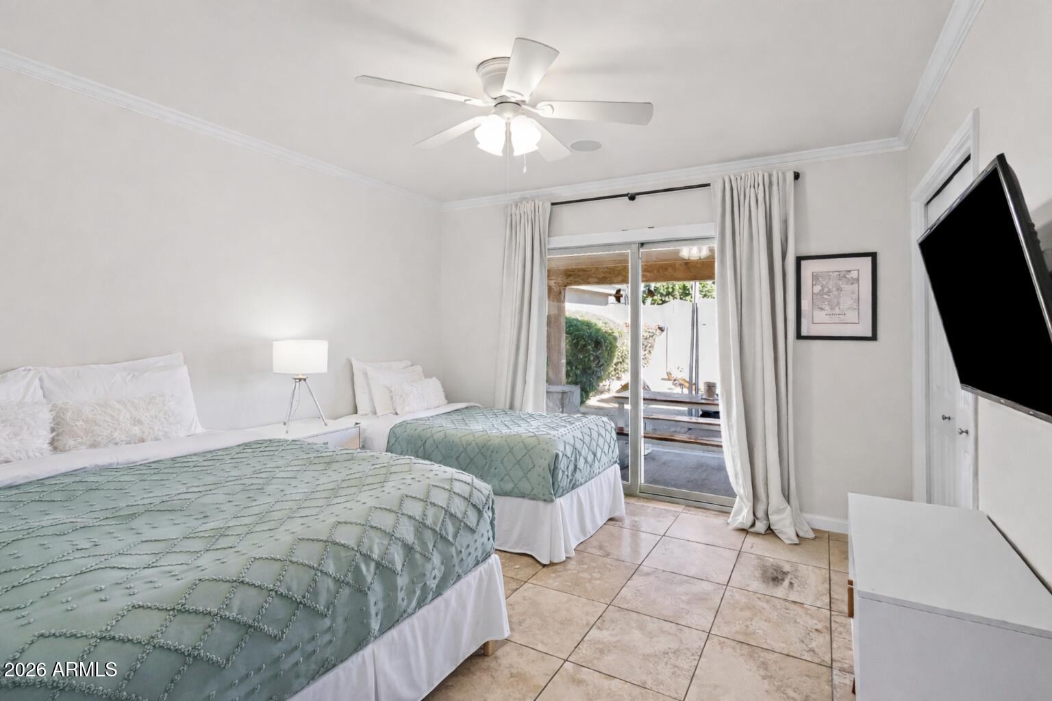 6810 East Granada Road Scottsdale, AZ 85257 - Photo 26 of 34 a spacious bedroom with a bed and a flat screen tv