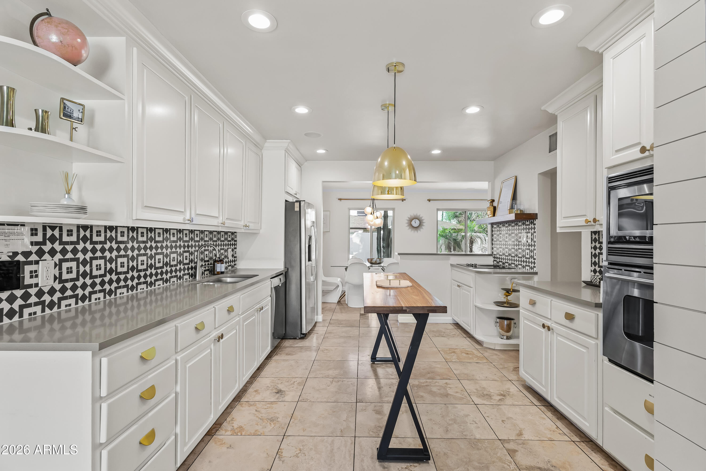 6810 East Granada Road Scottsdale, AZ 85257 - Photo 10 of 34 a kitchen with kitchen island white cabinets and stainless steel appliances