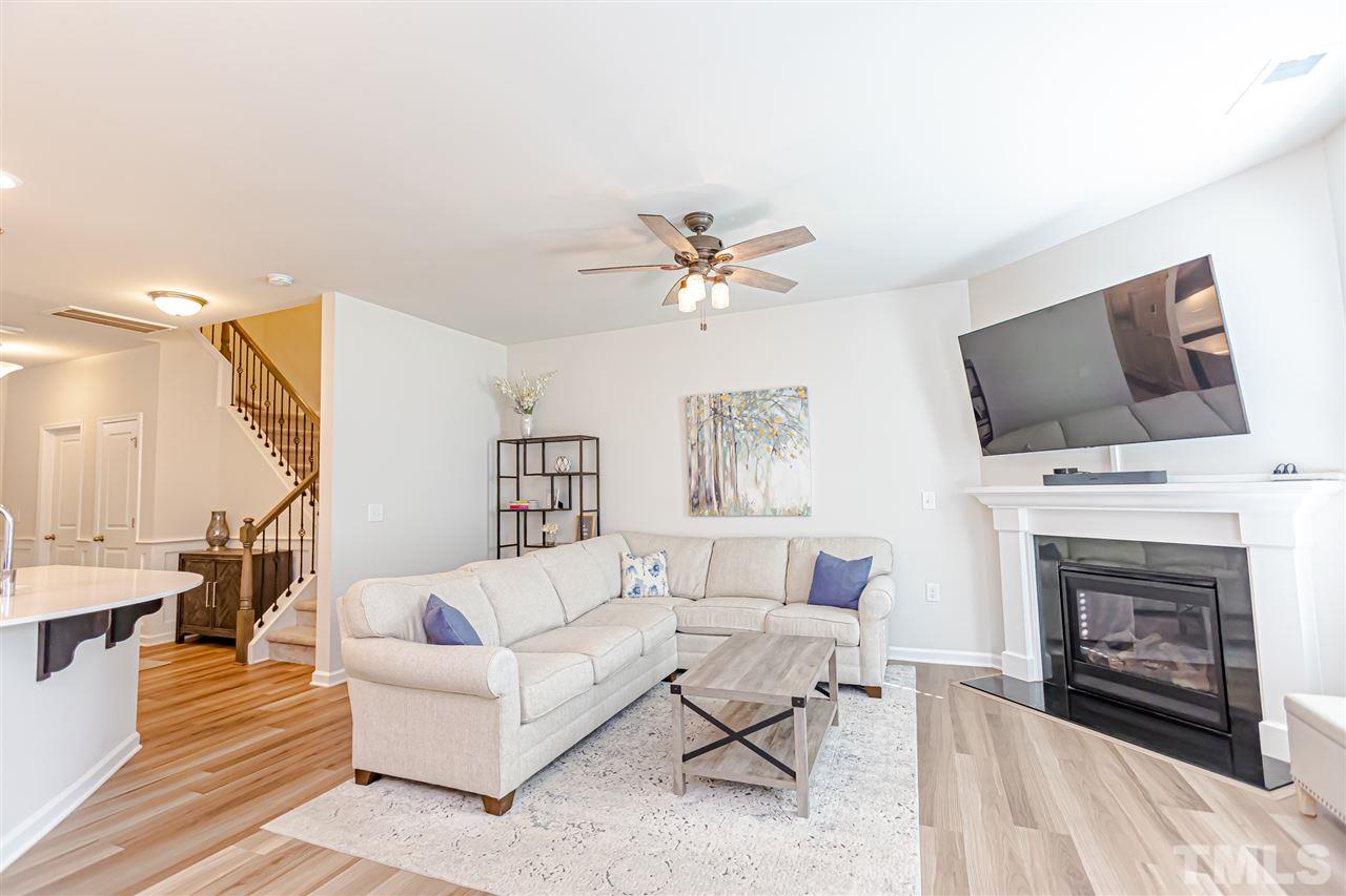 6123 Beale Loop Raleigh, NC 27616 - Photo 15 of 30 a living room with furniture a fireplace and a flat screen tv
