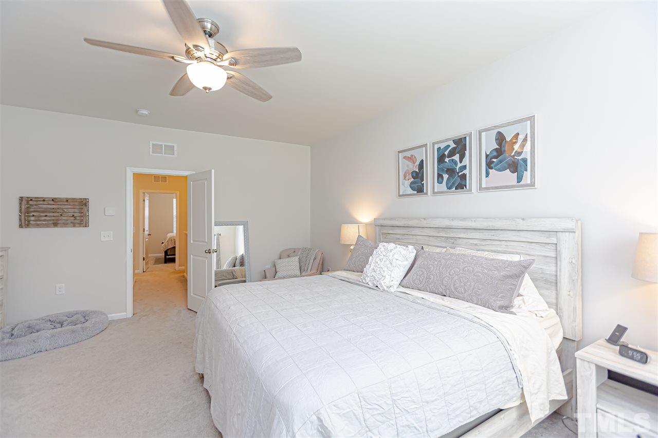6123 Beale Loop Raleigh, NC 27616 - Photo 18 of 30 a bedroom with a large bed and a chandelier