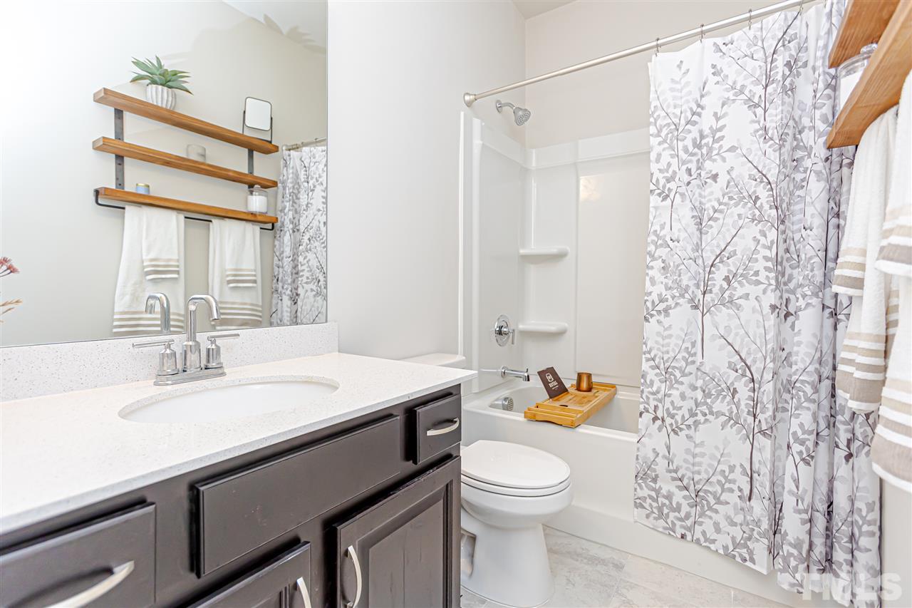 6123 Beale Loop Raleigh, NC 27616 - Photo 25 of 30 a bathroom with a sink a toilet and shower curtain
