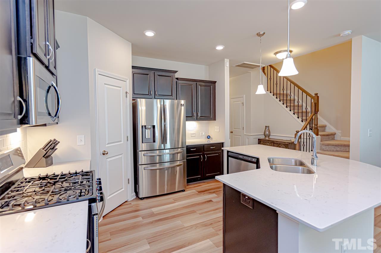 6123 Beale Loop Raleigh, NC 27616 - Photo 6 of 30 a kitchen with kitchen island granite countertop a sink stove and refrigerator