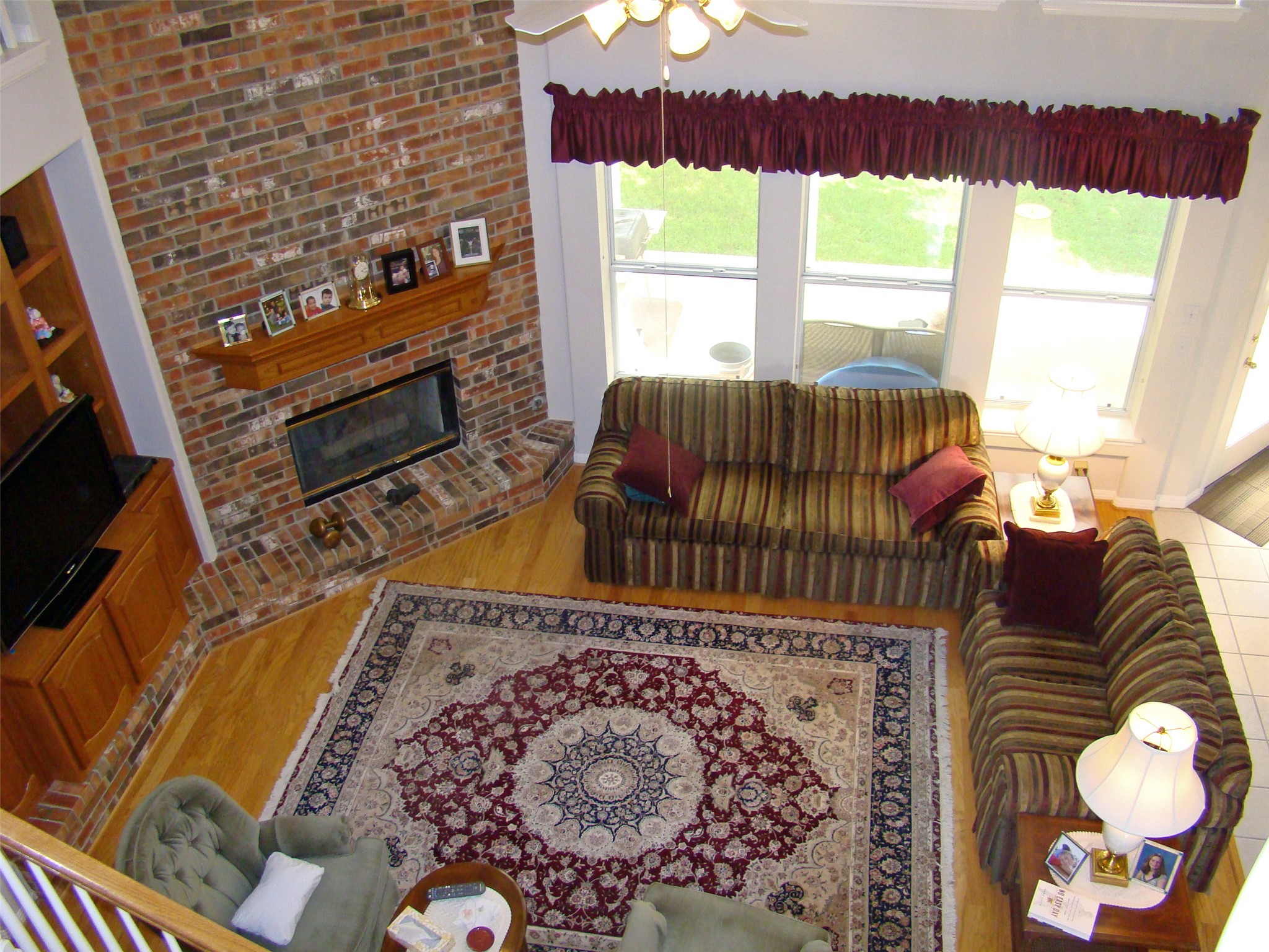 10700 Pointe View Drive Austin, TX 78738 - Photo 11 of 22 Living room with ceiling fan, light wood-style flooring, and a brick fireplace
