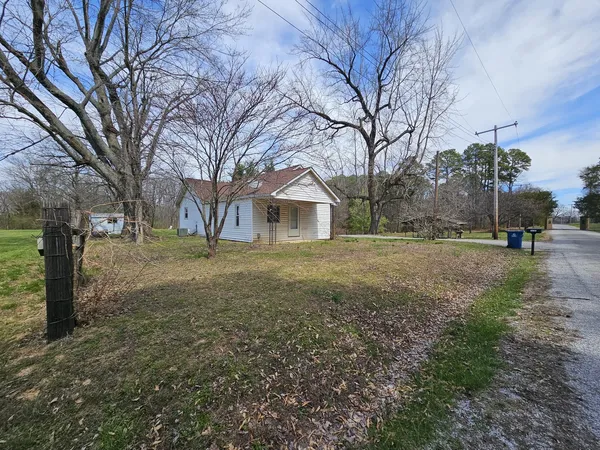 a view of a yard with a house and a tree