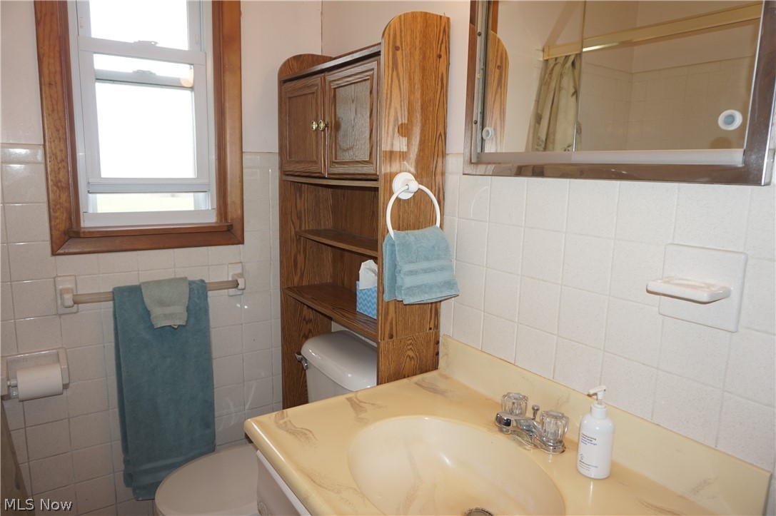 2465 South Ridge Road East Ashtabula, OH 44004 - Photo 20 of 38 Bathroom with tasteful backsplash, toilet, vanity, and tile walls