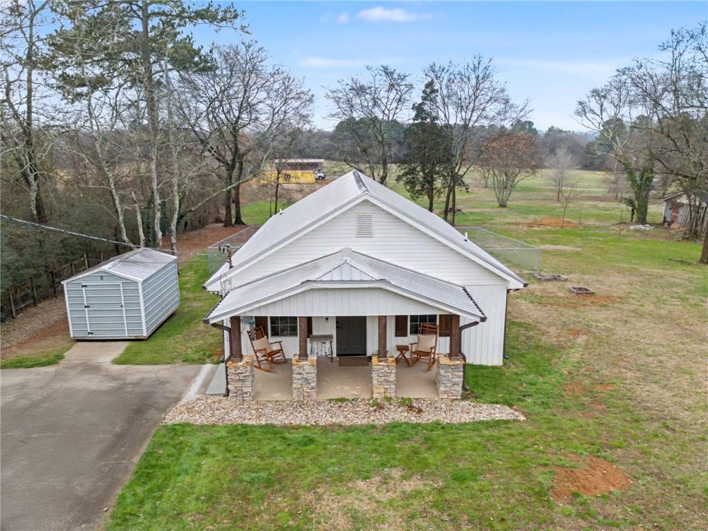 a aerial view of a house next to a big yard and large trees