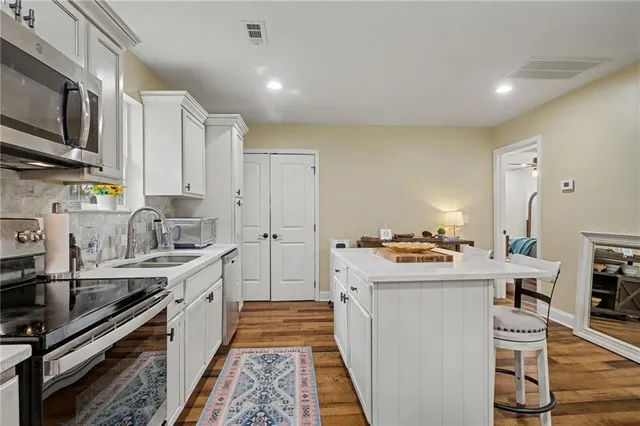 a kitchen with stainless steel appliances a sink stove top oven and cabinets