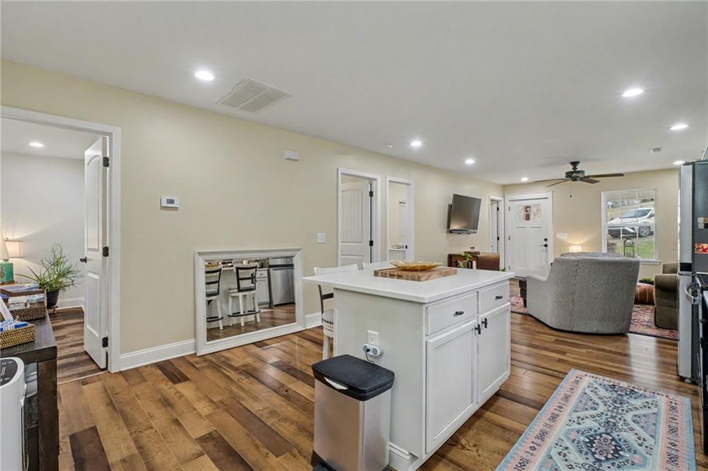 4843 Calhoun Road Northeast Rome, GA 30161 - Photo 13 of 56 a large kitchen with kitchen island a sink a stove and wooden floor