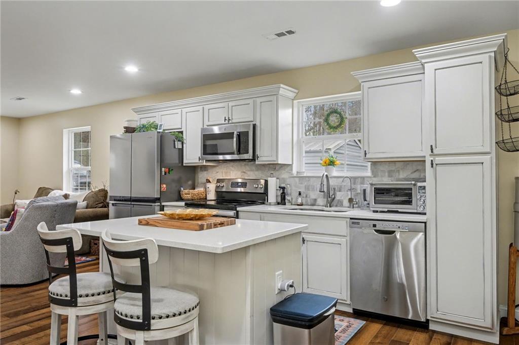 4843 Calhoun Road Northeast Rome, GA 30161 - Photo 16 of 56 a kitchen with stainless steel appliances stove refrigerator dining table and chairs