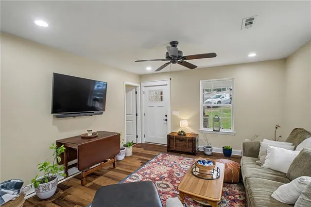 a living room with furniture a flat screen tv and a window