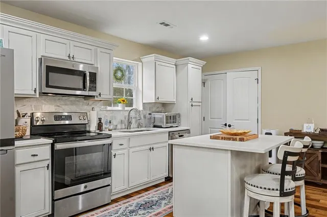a kitchen with stainless steel appliances a stove sink microwave and cabinets