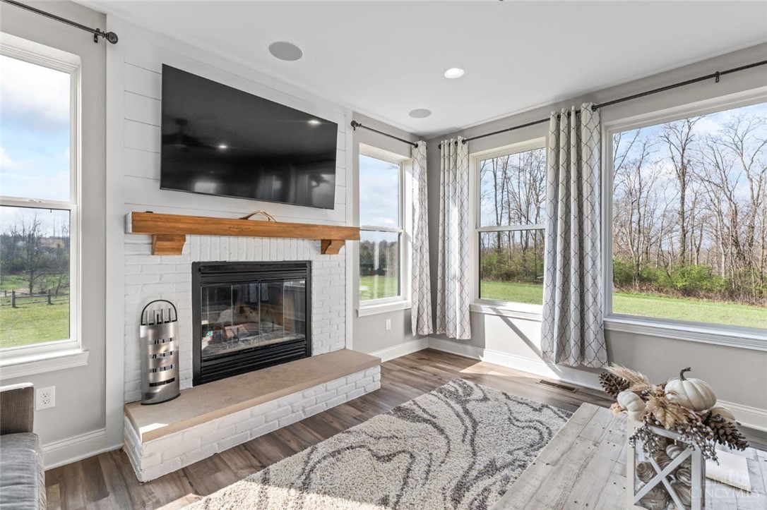 2425 Middleboro Road Clarksville, OH 45113 - Photo 33 of 91 This living area features a warm fireplace and large windows offering scenic outdoor views.