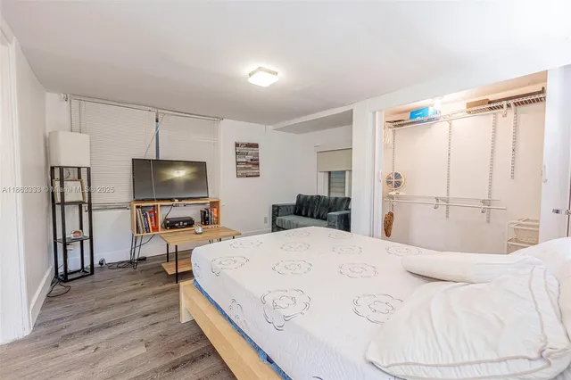 a bedroom with a bed and a flat screen tv