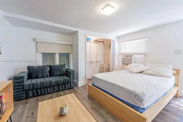 a bedroom with a bed couch and a window