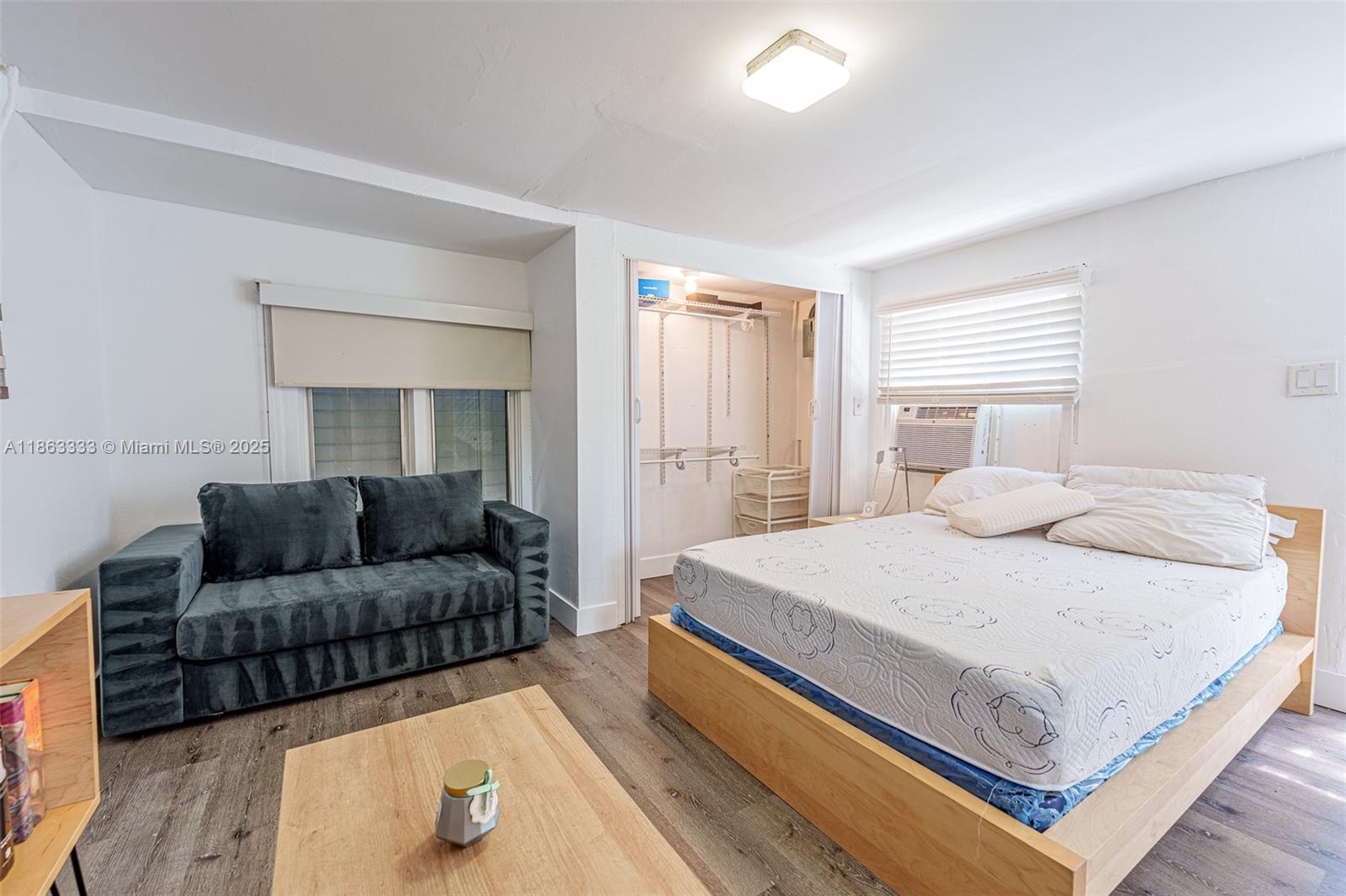 528 Southwest 21st Avenue, Unit B Miami, FL 33135 - Photo 2 of 7 a bedroom with a bed couch and a window