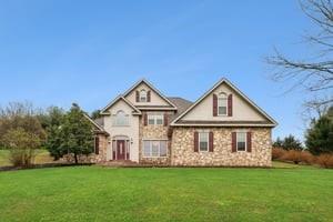 a view of a house with a big yard and large trees