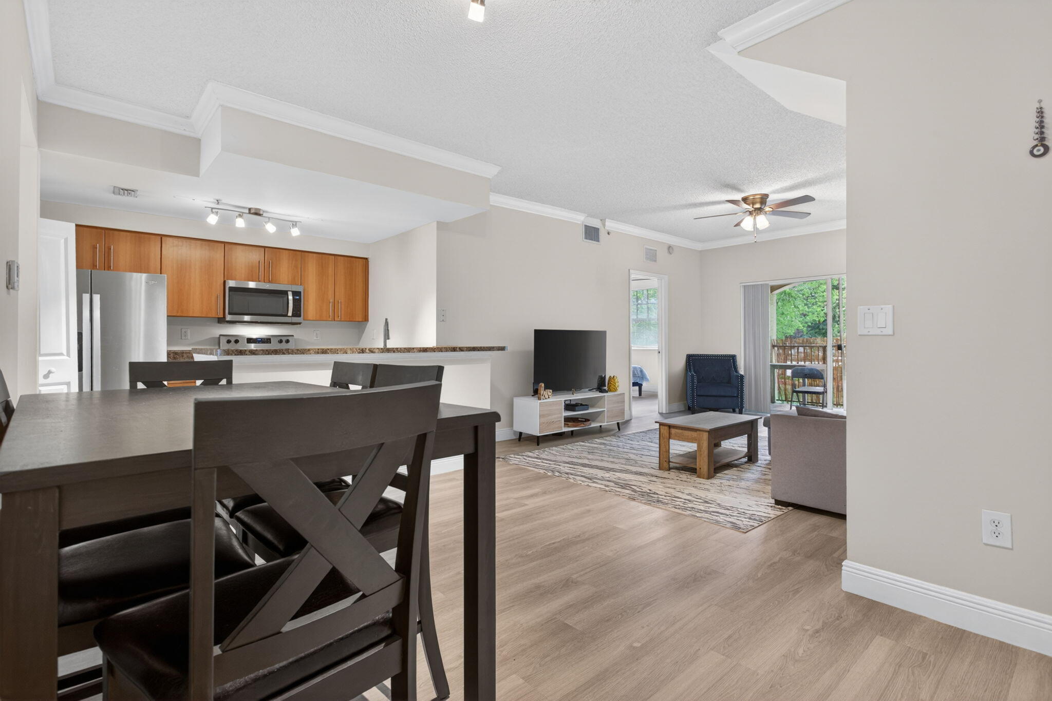 5880 West Sample Road, Unit 206 Coral Springs, FL 33067 - Photo 9 of 37 a living room with stainless steel appliances furniture a dining table and chairs