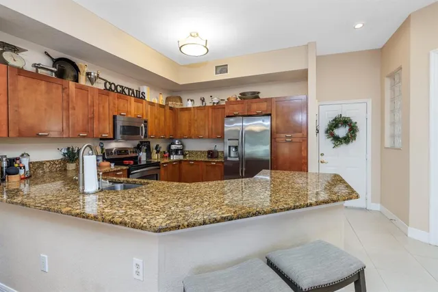 a kitchen with stainless steel appliances granite countertop a sink refrigerator and cabinets