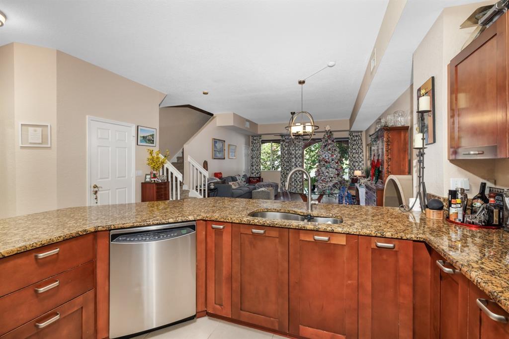 55 Southeast Palermo, Unit 105 Stuart, FL 34994 - Photo 15 of 40 a kitchen with stainless steel appliances granite countertop a sink a stove and a wooden cabinets