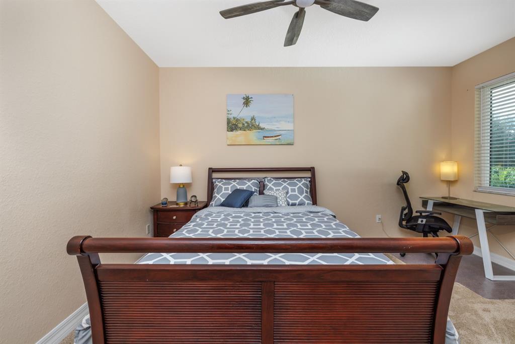 55 Southeast Palermo, Unit 105 Stuart, FL 34994 - Photo 25 of 40 a bedroom with a bed and a lamp on the table