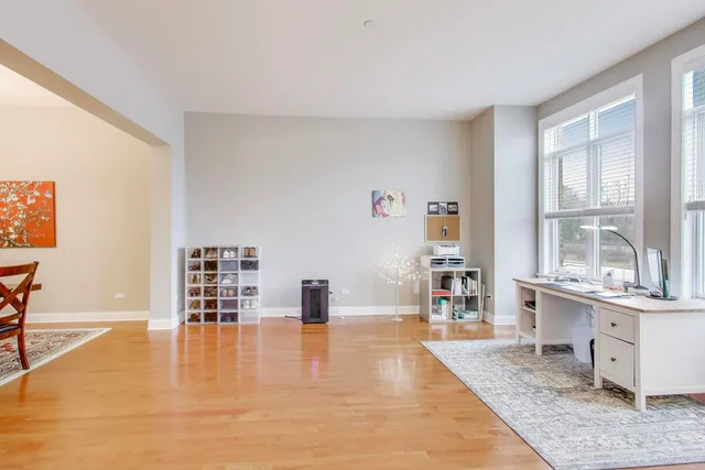 a living room with fireplace furniture and a dining table with wooden floor