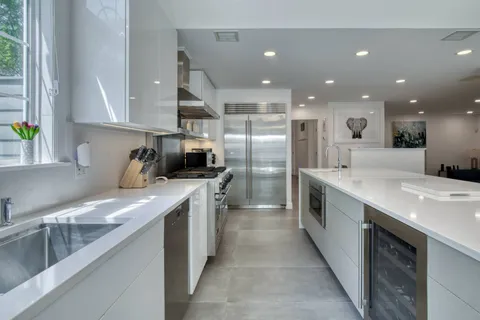 a large kitchen with stainless steel appliances kitchen island granite countertop a sink and cabinets