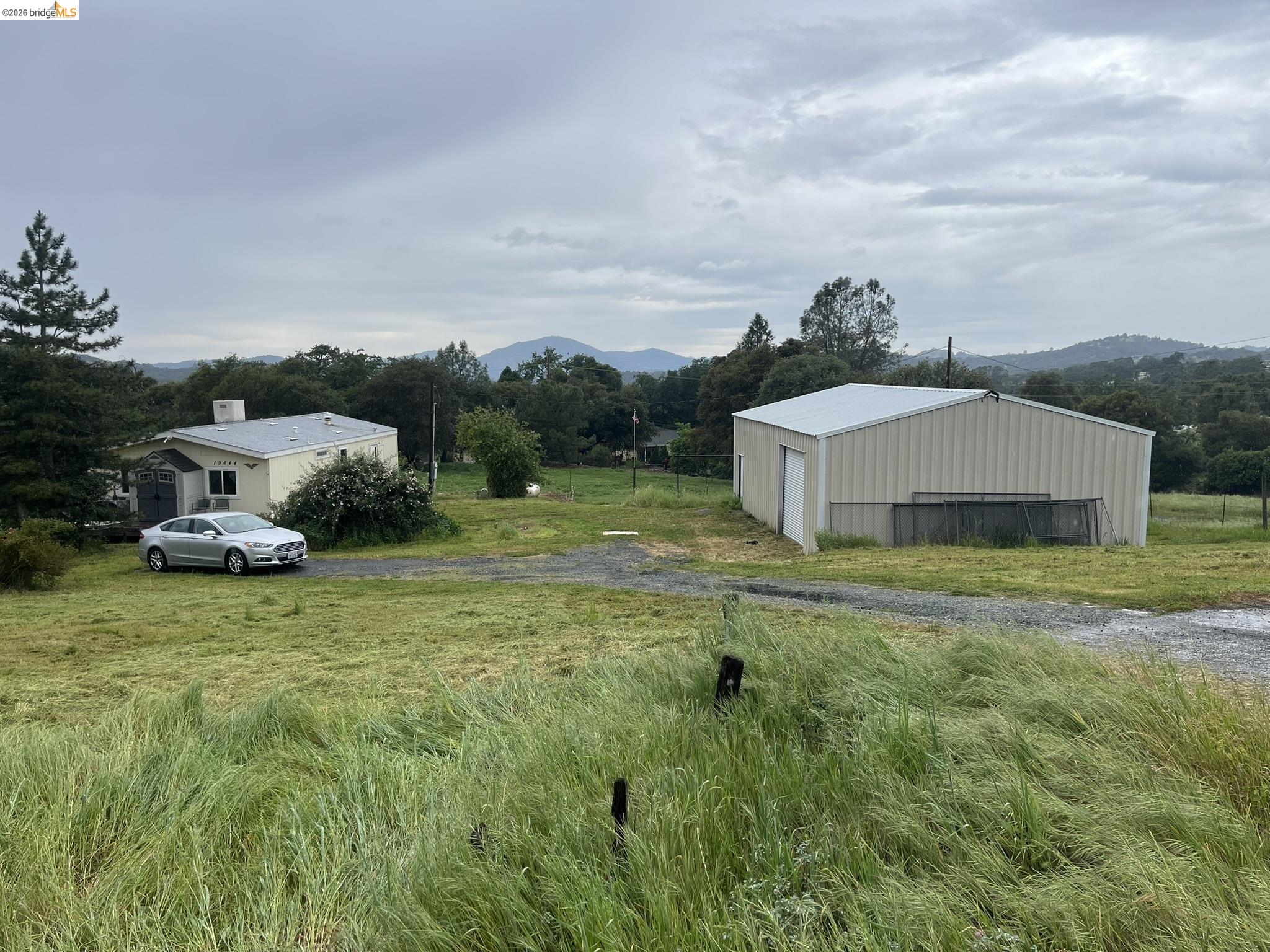 View of yard featuring an outbuilding, a mountain view, and a view of countryside