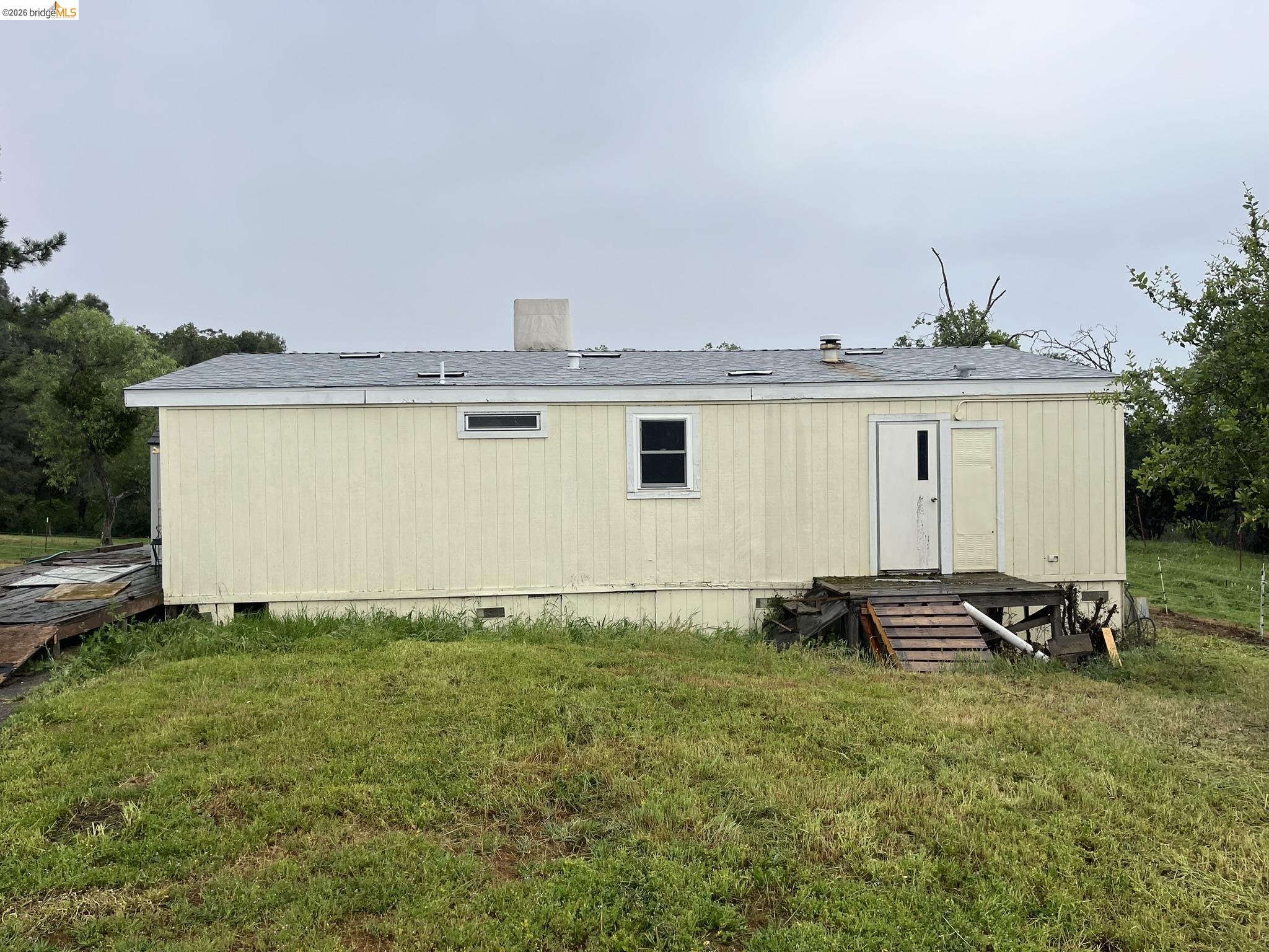 19644 Rawhide Road Sonora, CA 95370 - Photo 12 of 45 Rear view of property featuring a lawn, roof with shingles, and crawl space